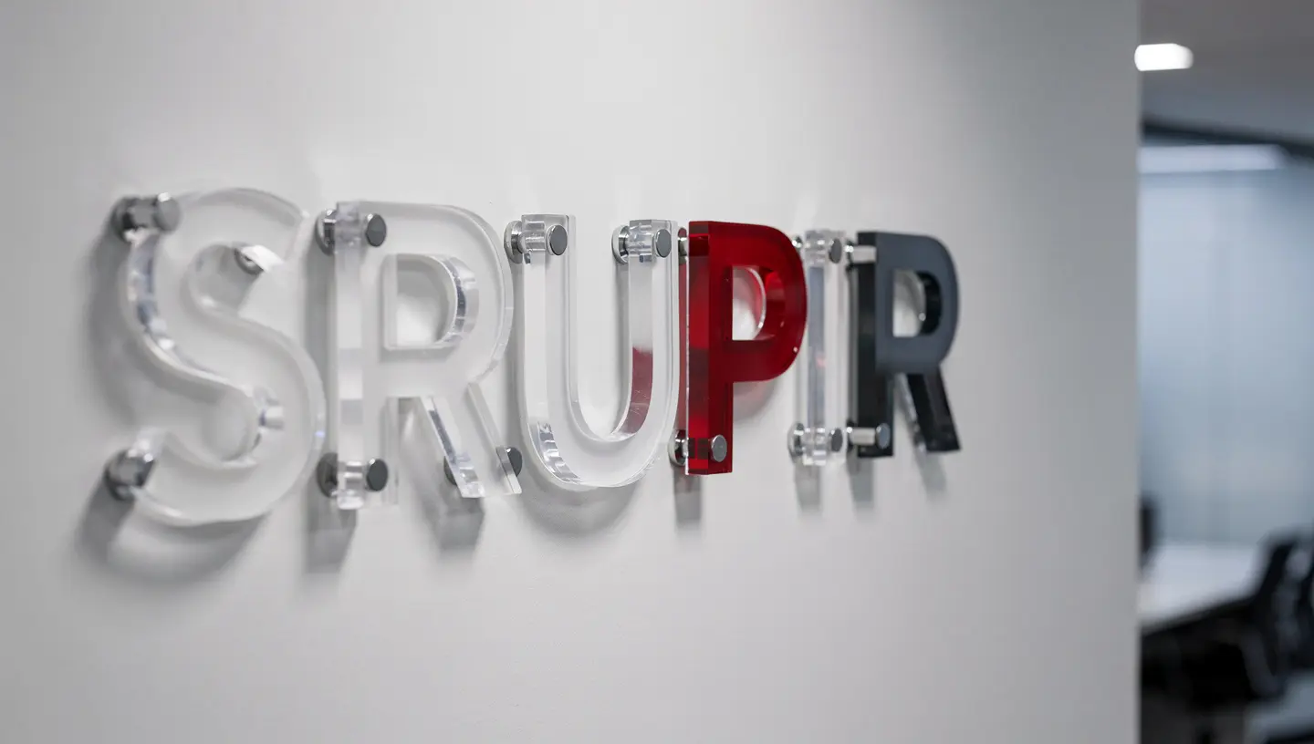 Close-up of layered acrylic dimensional letters with chrome standoff hardware