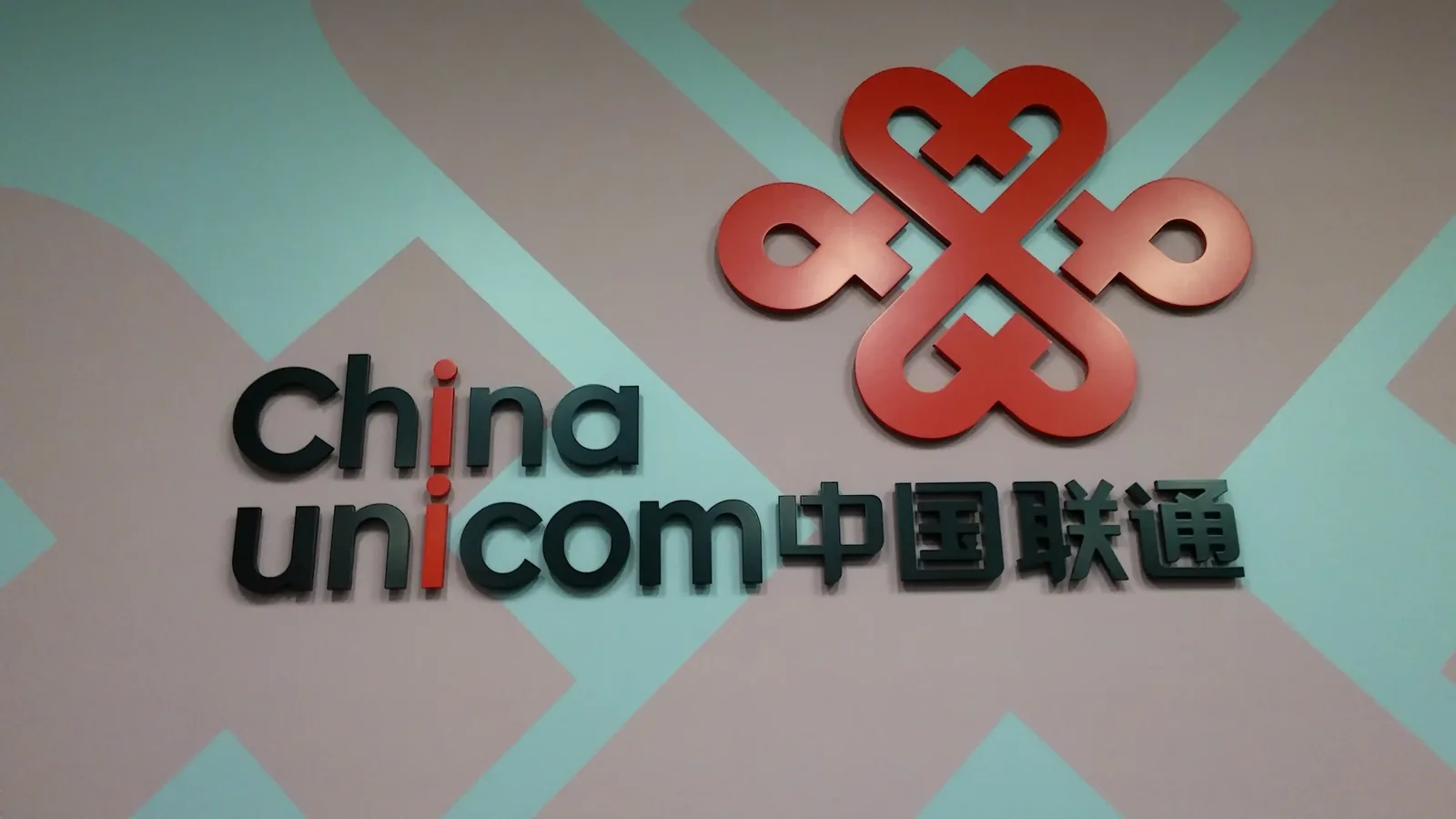 Dimensional acrylic logo and wordmark mounted over printed wall covering — China Unicom San Jose lobby