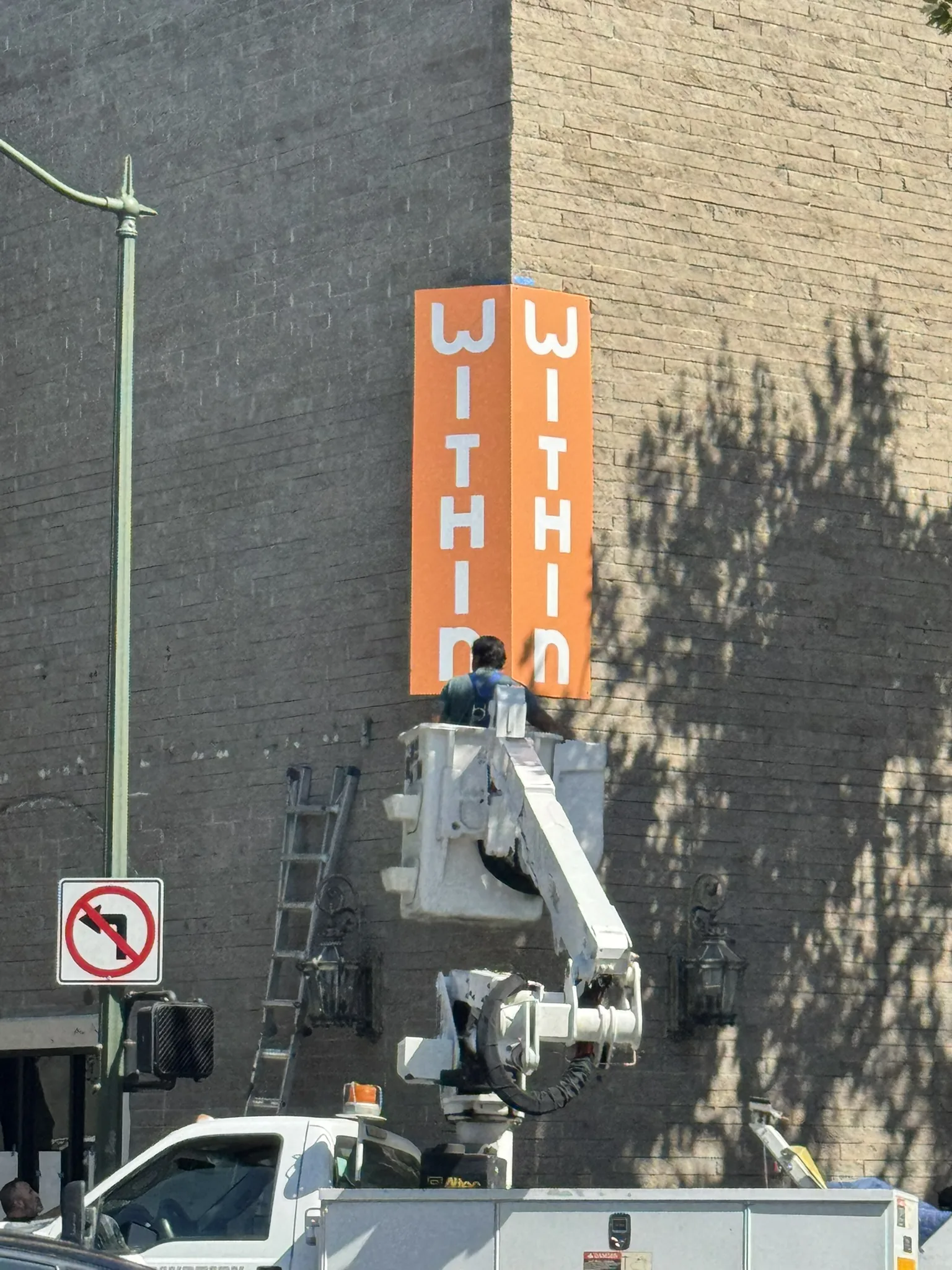 Corner blade sign installation on brick building corner